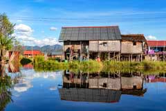 Typisches Pfahlbauhaus mit Spiegelung im Inle-See in Myanmar